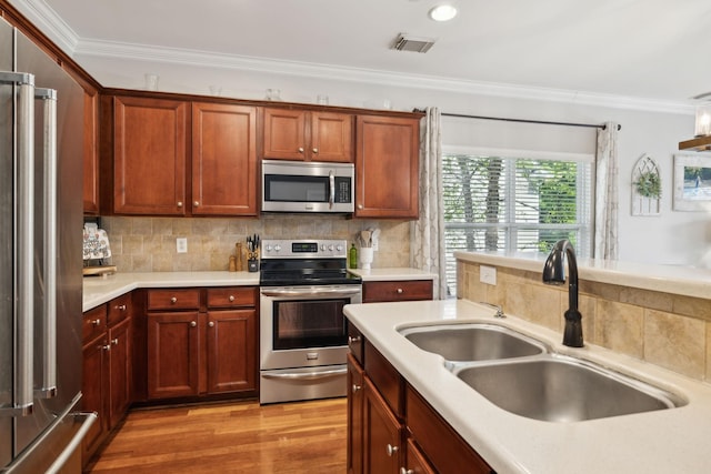 3324 Redmon Hl, Nolensville, TN 37135 - kitchen with stainless steel appliances, a sink, ornamental molding, light countertops, and light wood finished floors