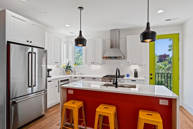 1203B Brick Church Pike, Nashville, TN 37207 - kitchen with appliances with stainless steel finishes, wall chimney range hood, backsplash, a sink, and a kitchen bar
