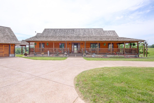 1820 Buck Smith Rd, Palmyra, TN 37142 - view of front facade with a porch, curved driveway, a front lawn, and a garage