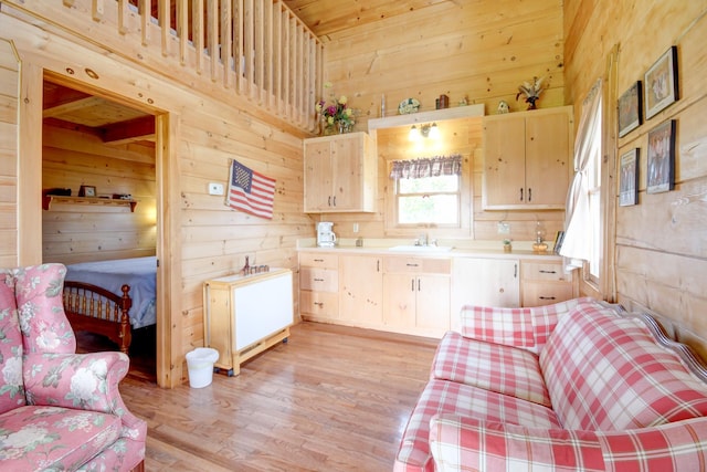 1820 Buck Smith Rd, Palmyra, TN 37142 - kitchen featuring wooden walls, light brown cabinetry, a sink, light countertops, and light wood finished floors