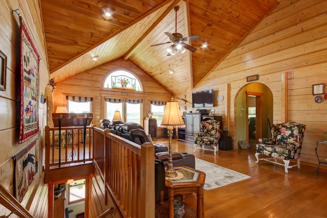 1820 Buck Smith Rd, Palmyra, TN 37142 - living room with wooden walls, arched walkways, wood finished floors, ceiling fan, and vaulted ceiling