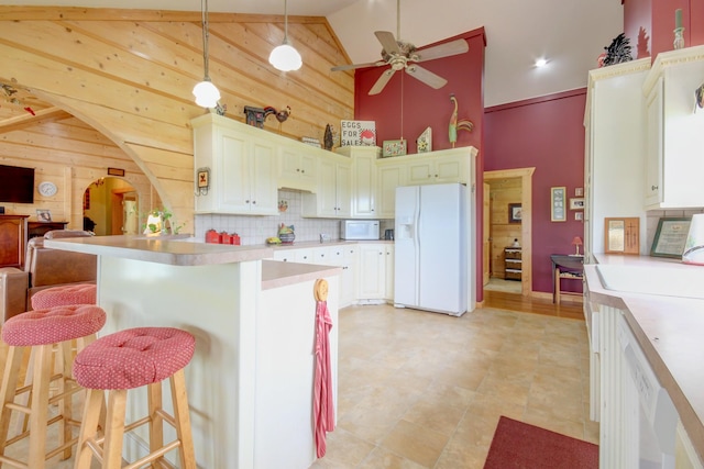 1820 Buck Smith Rd, Palmyra, TN 37142 - kitchen with white appliances, high vaulted ceiling, wood walls, light countertops, and a ceiling fan