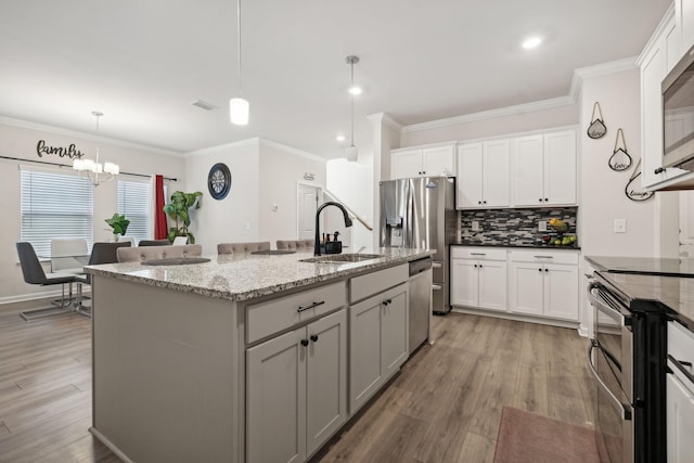 4537 Rockland Trl, Antioch, TN 37013 - kitchen featuring a sink, decorative backsplash, crown molding, an island with sink, and a chandelier