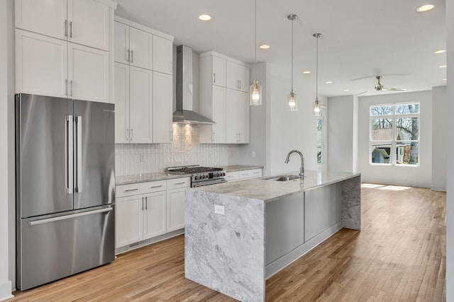2514B Booker St, Nashville, TN 37208 - kitchen featuring high end appliances, wall chimney range hood, a sink, white cabinets, and light wood finished floors