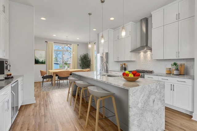 2514B Booker St, Nashville, TN 37208 - kitchen featuring wall chimney exhaust hood, a sink, tasteful backsplash, light wood-style flooring, and beverage cooler