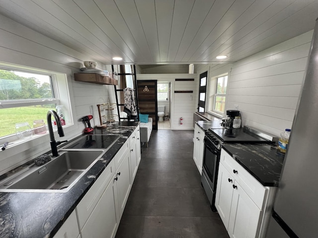 68 Bassham Rd, Five Points, TN 38457 - kitchen featuring stainless steel electric range, open shelves, dark countertops, wooden walls, and white cabinetry