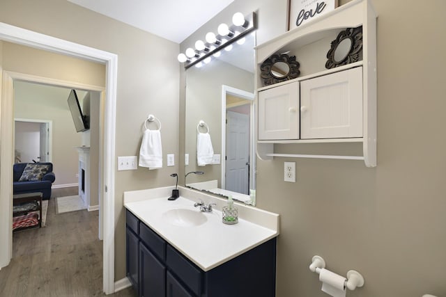 146 Sherron Dr, Dickson, TN 37055 - bathroom featuring vanity, a fireplace, wood finished floors, and baseboards