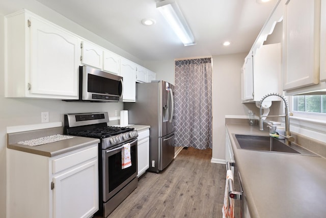 146 Sherron Dr, Dickson, TN 37055 - kitchen featuring appliances with stainless steel finishes, white cabinetry, a sink, light wood finished floors, and recessed lighting