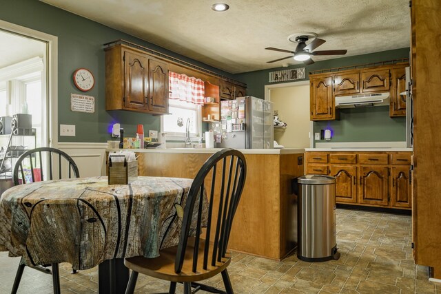 535 Dawson Rd, Cumberland Furnace, TN 37051 - kitchen with freestanding refrigerator, under cabinet range hood, a ceiling fan, stone finish flooring, and wainscoting