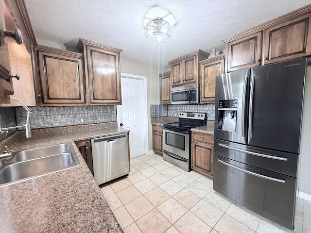 309 Caydras Way, Lafayette, TN 37083 - kitchen featuring stainless steel appliances, decorative backsplash, a sink, light tile patterned floors, and a textured ceiling