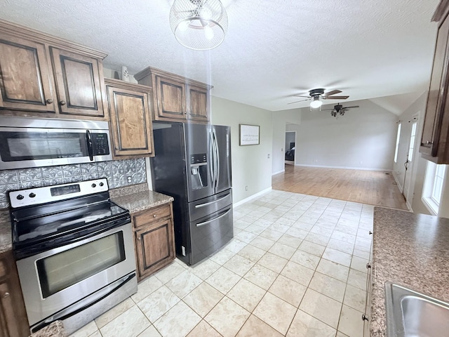 309 Caydras Way, Lafayette, TN 37083 - kitchen with appliances with stainless steel finishes, ceiling fan, tasteful backsplash, baseboards, and a textured ceiling