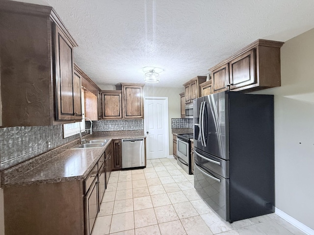 309 Caydras Way, Lafayette, TN 37083 - kitchen featuring stainless steel appliances, a sink, backsplash, and dark brown cabinetry