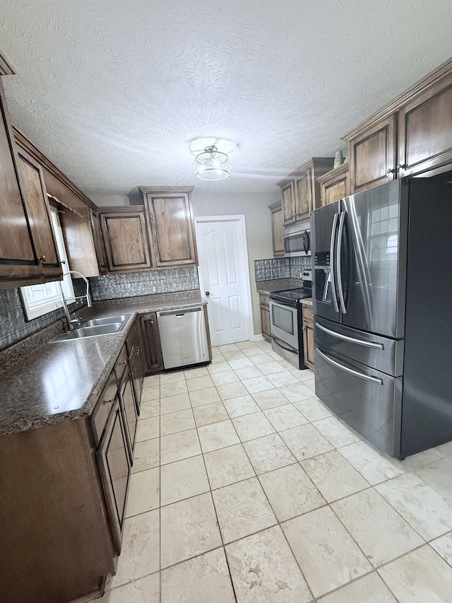 309 Caydras Way, Lafayette, TN 37083 - kitchen featuring appliances with stainless steel finishes, a sink, dark countertops, tasteful backsplash, and light tile patterned flooring