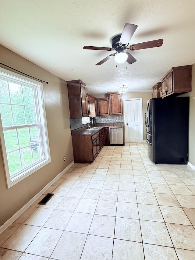 309 Caydras Way, Lafayette, TN 37083 - kitchen featuring freestanding refrigerator, stainless steel dishwasher, ceiling fan, light tile patterned floors, and backsplash