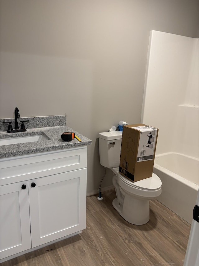 615 6th Ave N, Lewisburg, TN 37091 - bathroom featuring toilet, wood finished floors, a bathtub, vanity, and baseboards