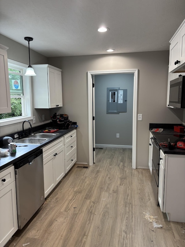 615 6th Ave N, Lewisburg, TN 37091 - kitchen with appliances with stainless steel finishes, a sink, dark countertops, white cabinetry, and light wood-style floors