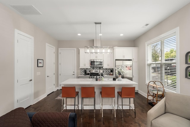 507 Vernon Cir, Nashville, TN 37209 - kitchen with appliances with stainless steel finishes, a kitchen breakfast bar, decorative backsplash, a kitchen island with sink, and recessed lighting
