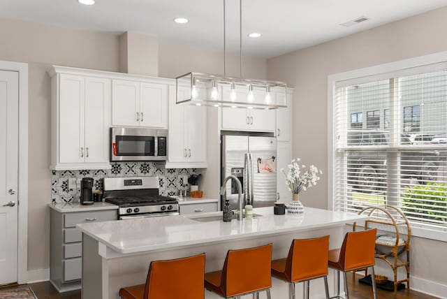 507 Vernon Cir, Nashville, TN 37209 - kitchen featuring appliances with stainless steel finishes, a sink, light countertops, tasteful backsplash, and a center island with sink