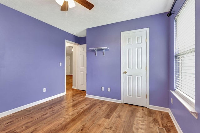 2312 Forrest Fields Dr, Chapel Hill, TN 37034 - unfurnished bedroom featuring baseboards, multiple windows, wood finished floors, ceiling fan, and a textured ceiling