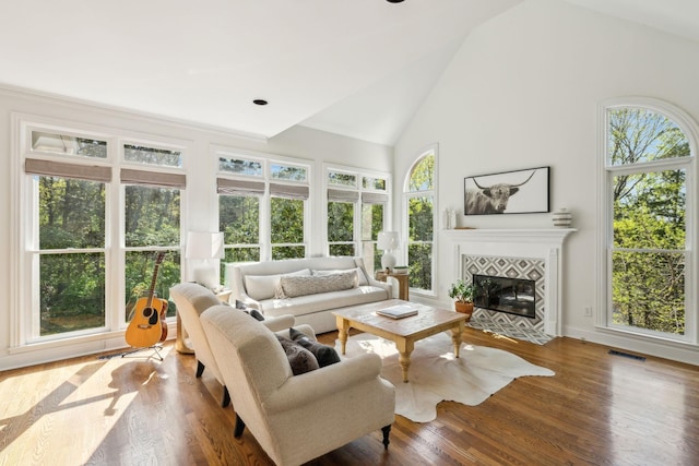 6321 Wescates, Brentwood, TN 37027 - living area featuring plenty of natural light, a tiled fireplace, wood finished floors, high vaulted ceiling, and baseboards