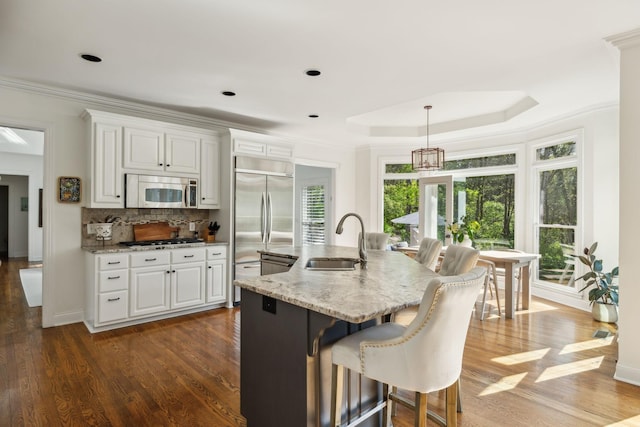 6321 Wescates, Brentwood, TN 37027 - kitchen featuring appliances with stainless steel finishes, a sink, white cabinetry, light stone countertops, and ornamental molding