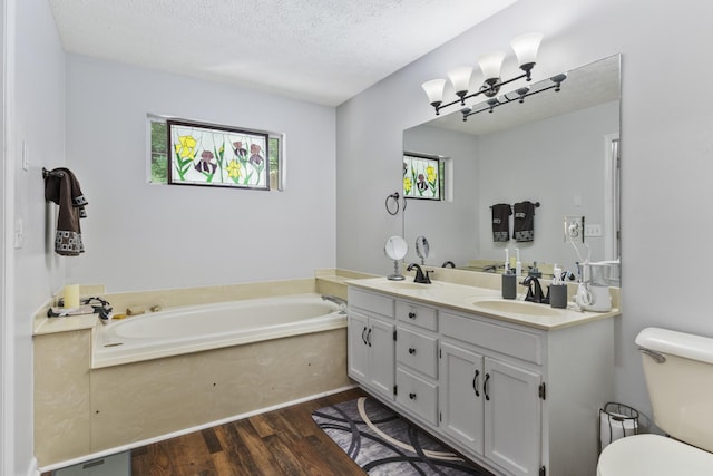5156 W Oak Highland Dr, Antioch, TN 37013 - full bathroom featuring wood finished floors, a bath, toilet, double vanity, and a textured ceiling
