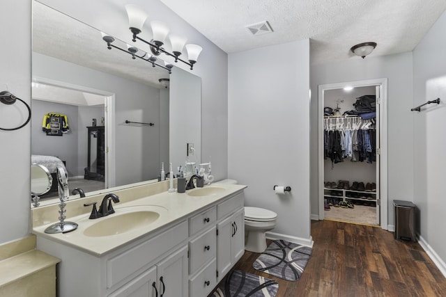 5156 W Oak Highland Dr, Antioch, TN 37013 - ensuite bathroom featuring double vanity, wood finished floors, baseboards, a walk in closet, and toilet
