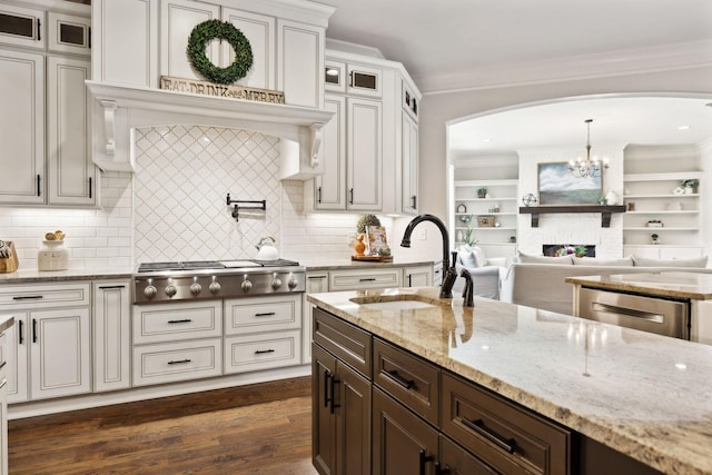 1234 Saddle Springs Dr, Thompsons Station, TN 37179 - kitchen with arched walkways, a sink, stainless steel appliances, glass insert cabinets, and dark wood-style floors