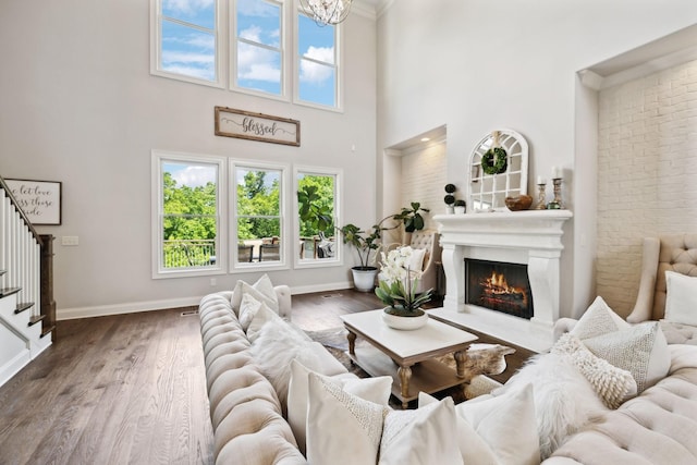 1234 Saddle Springs Dr, Thompsons Station, TN 37179 - living area with stairway, a towering ceiling, a warm lit fireplace, wood finished floors, and baseboards