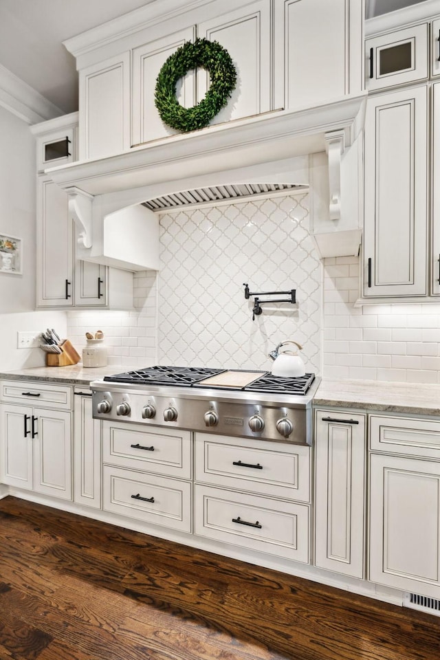 1234 Saddle Springs Dr, Thompsons Station, TN 37179 - kitchen with stainless steel gas stovetop, backsplash, glass insert cabinets, and white cabinets