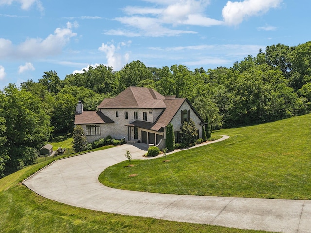 1234 Saddle Springs Dr, Thompsons Station, TN 37179 - view of front facade with driveway, a front lawn, stone siding, a chimney, and an attached garage