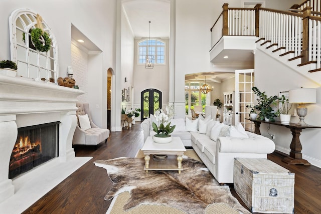 1234 Saddle Springs Dr, Thompsons Station, TN 37179 - living area featuring french doors, arched walkways, a towering ceiling, a chandelier, and wood finished floors