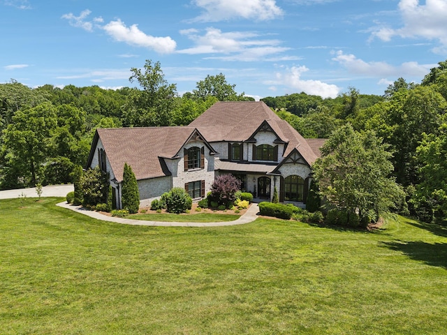 1234 Saddle Springs Dr, Thompsons Station, TN 37179 - tudor-style house with stone siding and a front lawn