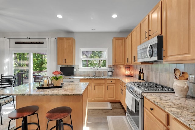 1154 Olde Cameron Ln, Franklin, TN 37067 - kitchen featuring appliances with stainless steel finishes, a sink, light brown cabinetry, a breakfast bar area, and recessed lighting