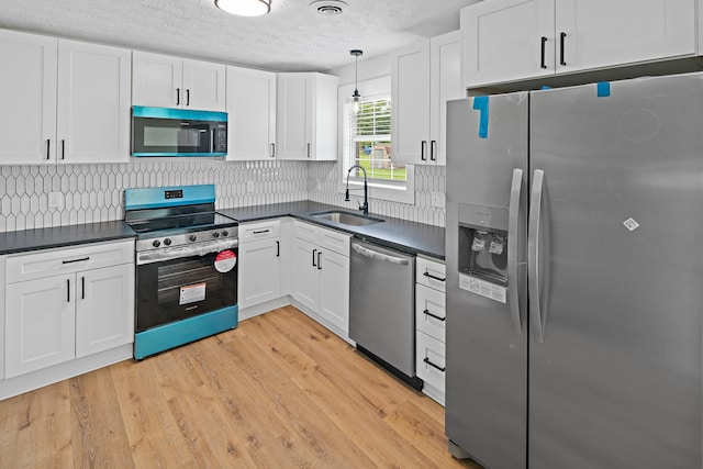 316 Bybee Branch Rd, Mcminnville, TN 37110 - kitchen featuring stainless steel appliances, a sink, dark countertops, white cabinets, and a textured ceiling