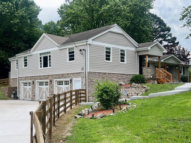 5935 S New Hope Rd, Hermitage, TN 37076 - view of front facade with a garage, concrete driveway, stone siding, and a porch