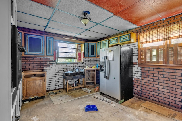 615 Oliver Smith Rd, Flintville, TN 37335 - kitchen with stainless steel fridge, brick wall, a paneled ceiling, and oven
