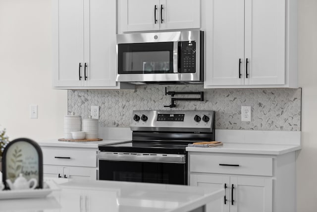 583 Pongracz Way, Clarksville, TN 37042 - kitchen with stainless steel appliances, light countertops, white cabinetry, and backsplash