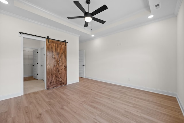 583 Pongracz Way, Clarksville, TN 37042 - unfurnished bedroom with a barn door, a raised ceiling, ornamental molding, light wood-style flooring, and recessed lighting