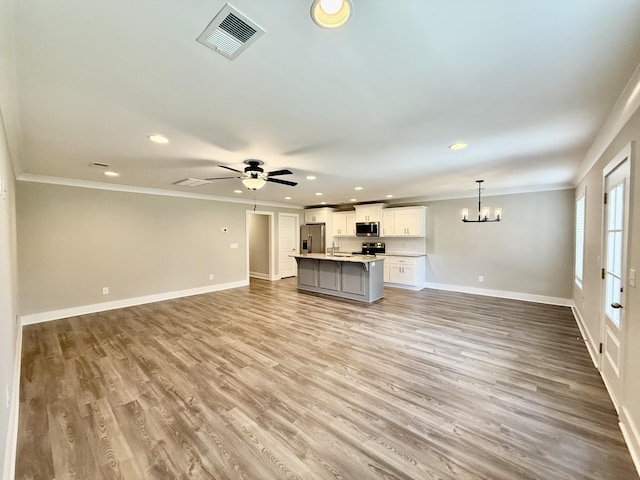 5608 Maples Retreat Dr, Murfreesboro, TN 37127 - unfurnished living room featuring ornamental molding, recessed lighting, a chandelier, baseboards, and light wood-type flooring