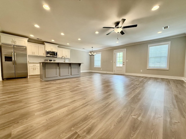 5608 Maples Retreat Dr, Murfreesboro, TN 37127 - unfurnished living room with ornamental molding, recessed lighting, ceiling fan, baseboards, and a chandelier