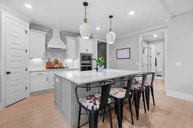 4010 Planters Trl, Mount Juliet, TN 37122 - kitchen with premium range hood, decorative backsplash, a kitchen bar, a center island with sink, and recessed lighting