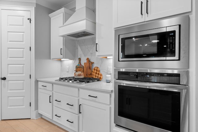 4010 Planters Trl, Mount Juliet, TN 37122 - kitchen featuring appliances with stainless steel finishes, custom exhaust hood, backsplash, light countertops, and white cabinets
