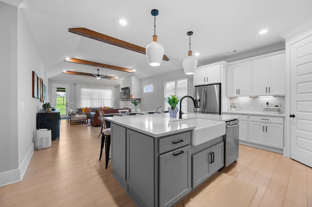 4010 Planters Trl, Mount Juliet, TN 37122 - kitchen with appliances with stainless steel finishes, gray cabinetry, light countertops, light wood finished floors, and decorative backsplash