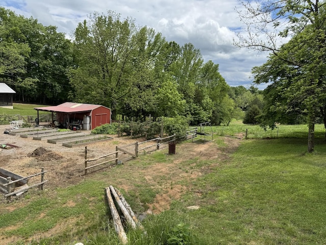 1829 Lobelville Hwy, Linden, TN 37096 - view of yard featuring a pole building, an outdoor structure, a vegetable garden, a forest view, and a garage
