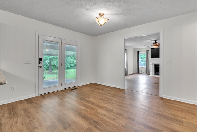 3471 Esquire Dr, Murfreesboro, TN 37130 - unfurnished room featuring wood finished floors, a textured ceiling, a fireplace, baseboards, and a ceiling fan
