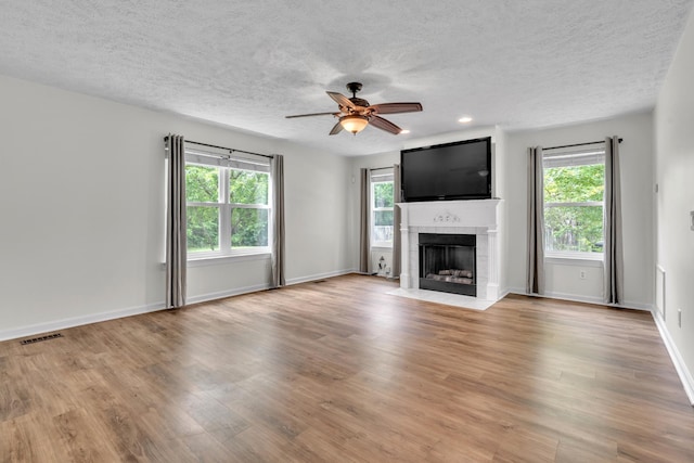 3471 Esquire Dr, Murfreesboro, TN 37130 - unfurnished living room with a tiled fireplace, light wood finished floors, a textured ceiling, ceiling fan, and baseboards