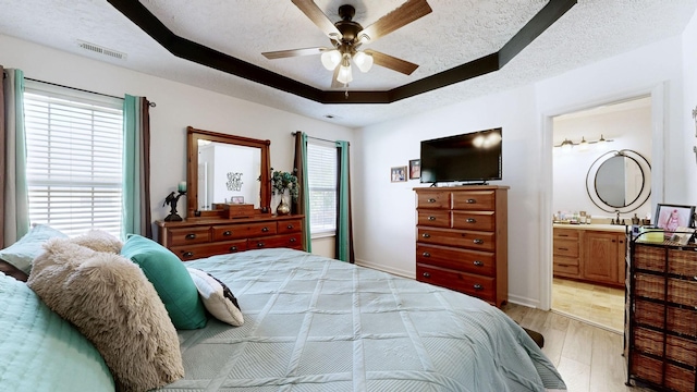 813 Chaney Woods Dr, La Vergne, TN 37086 - bedroom with light wood-style flooring, a tray ceiling, a textured ceiling, a ceiling fan, and ensuite bath