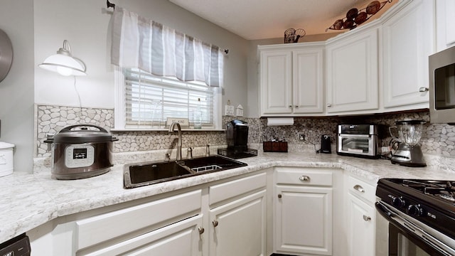 813 Chaney Woods Dr, La Vergne, TN 37086 - kitchen featuring a sink, white cabinetry, decorative backsplash, light countertops, and appliances with stainless steel finishes