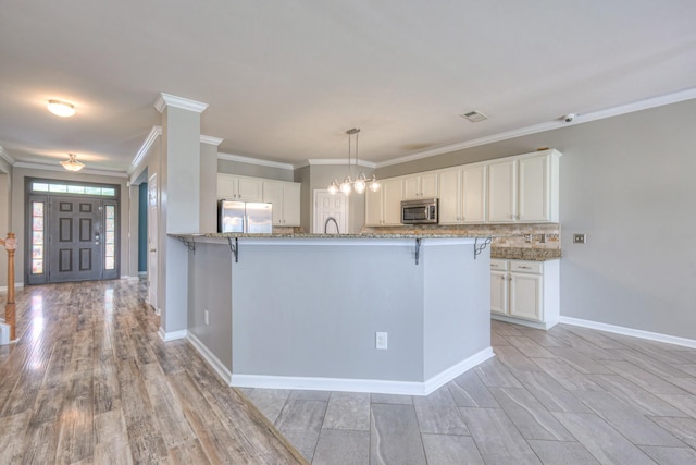 21 Cypress Hill Dr, Lebanon, TN 37087 - kitchen with appliances with stainless steel finishes, a breakfast bar area, light stone countertops, and ornamental molding
